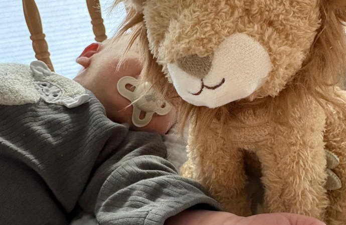 Baby mit Kuscheltier im Arm